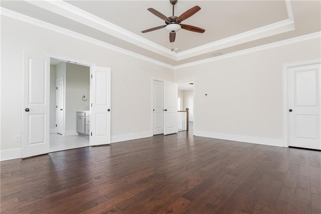 spare room with ceiling fan, dark hardwood / wood-style flooring, ornamental molding, and a tray ceiling