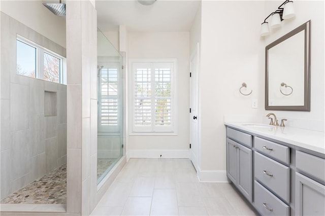 bathroom with tile patterned flooring, vanity, and tiled shower