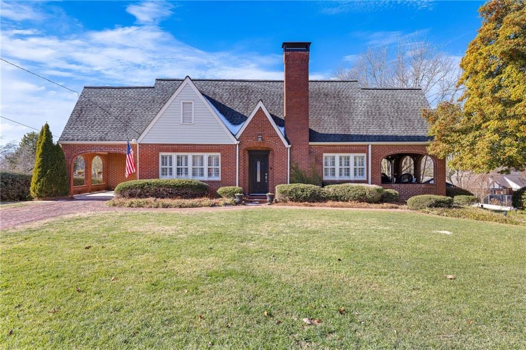 tudor home with a front lawn