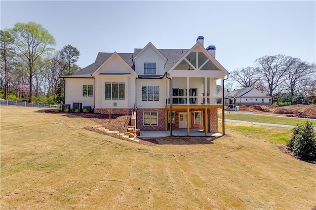 back of house with central AC, a patio, and a lawn