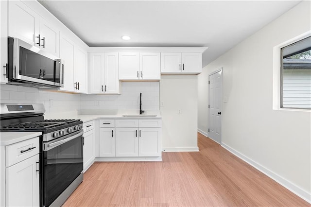 kitchen featuring white cabinets, appliances with stainless steel finishes, and sink