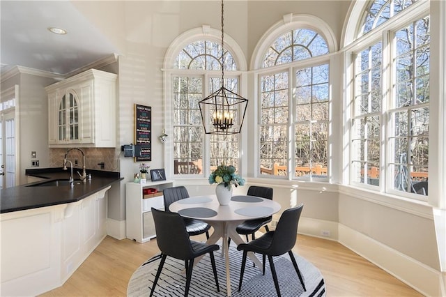 dining space with an inviting chandelier, light wood-style flooring, and a wealth of natural light