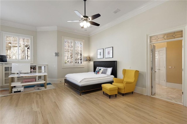 bedroom with ornamental molding, light wood-type flooring, and multiple windows