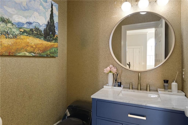 bathroom featuring vanity and wallpapered walls