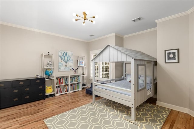 bedroom featuring a chandelier, wood finished floors, visible vents, baseboards, and ornamental molding