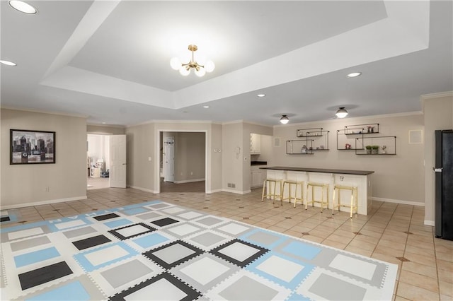 interior space with light tile patterned floors, recessed lighting, a notable chandelier, ornamental molding, and a raised ceiling