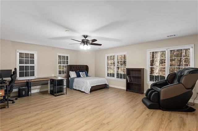 bedroom featuring visible vents, ceiling fan, light wood-style flooring, and baseboards