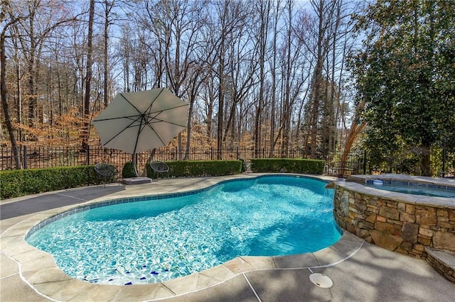 view of swimming pool featuring fence, a fenced in pool, and an in ground hot tub