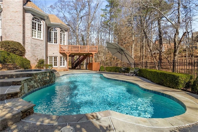 view of swimming pool with fence, stairway, a wooden deck, and a patio