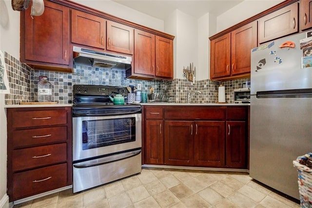 kitchen with tasteful backsplash, stainless steel appliances, light countertops, under cabinet range hood, and a sink