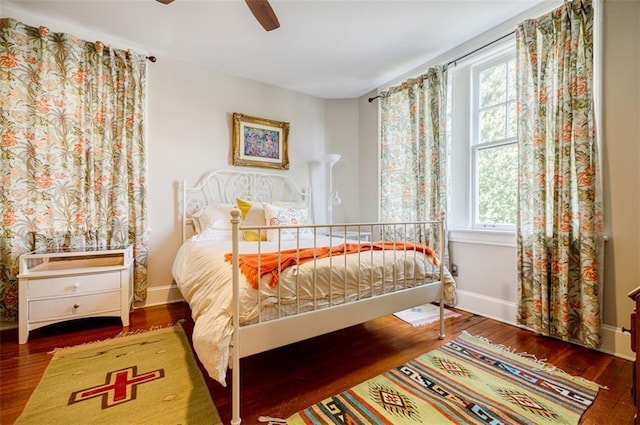 bedroom featuring wood finished floors, a ceiling fan, and baseboards