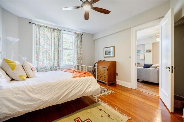 bedroom with a ceiling fan, baseboards, and wood finished floors