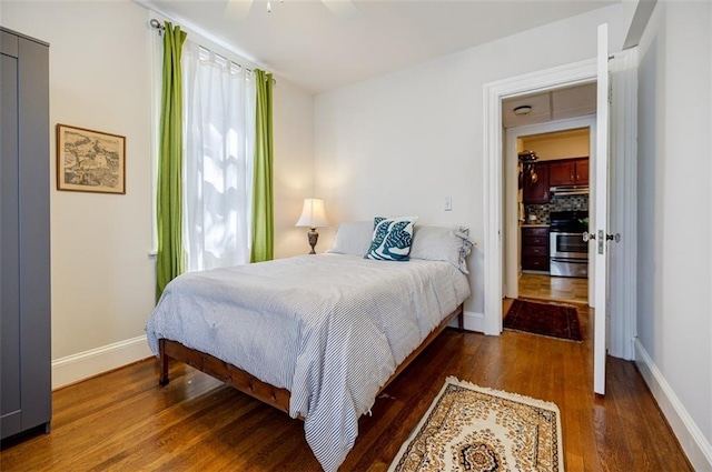 bedroom featuring wood finished floors, a ceiling fan, and baseboards