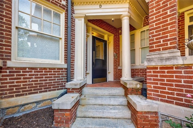 property entrance with brick siding and a porch