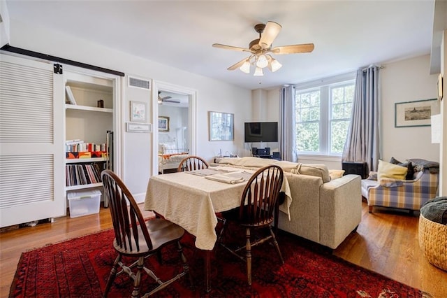 dining room featuring ceiling fan, wood finished floors, and visible vents