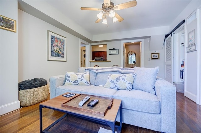 living room with baseboards, a ceiling fan, and wood finished floors