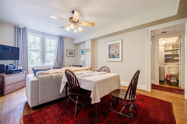 dining space featuring baseboards, a ceiling fan, and wood finished floors
