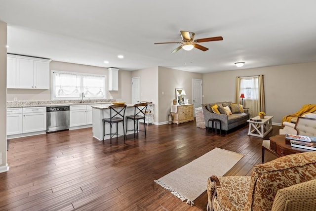 living room with ceiling fan, a healthy amount of sunlight, sink, and dark hardwood / wood-style flooring