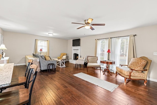 living room featuring dark wood-type flooring and ceiling fan