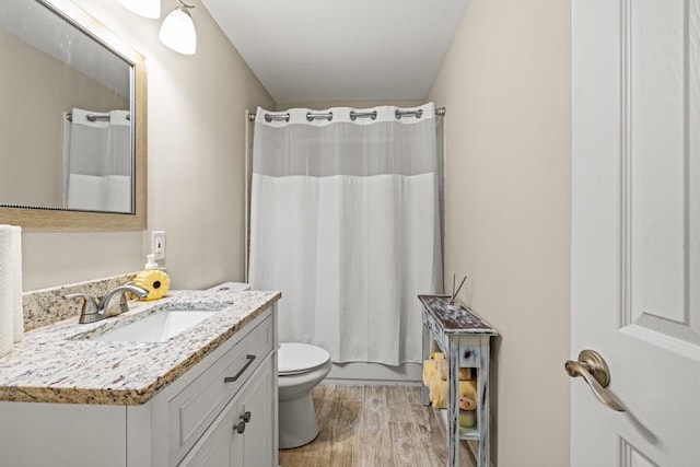 full bathroom with vanity, hardwood / wood-style floors, shower / bath combination with curtain, and toilet