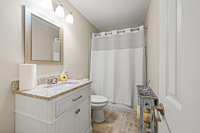 full bathroom with vanity, hardwood / wood-style floors, shower / bath combination with curtain, and toilet