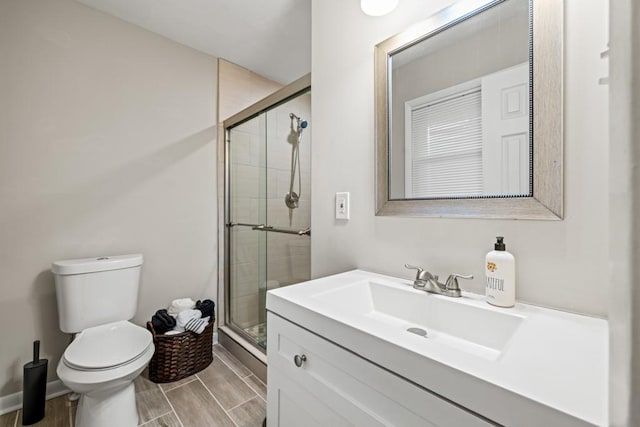 bathroom with vanity, an enclosed shower, and toilet