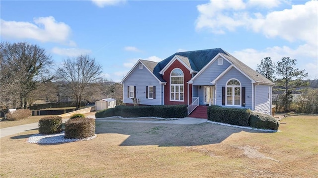 view of front of home with a shed, an outbuilding, and a front yard