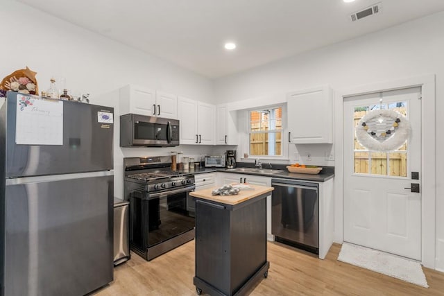 212 Haralson Ave NE, Atlanta, GA 30307 - kitchen with stainless steel appliances, a sink, butcher block counters, white cabinetry, and light wood finished floors