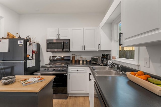 212 Haralson Ave NE, Atlanta, GA 30307 - kitchen featuring appliances with stainless steel finishes, a sink, wooden counters, light wood-type flooring, and white cabinets