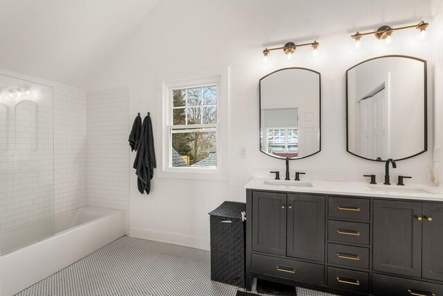 212 Haralson Ave NE, Atlanta, GA 30307 - full bathroom featuring double vanity, baseboards, vaulted ceiling, tile patterned floors, and shower / washtub combination
