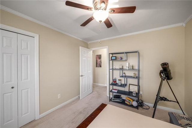 bedroom featuring a closet, baseboards, crown molding, and carpet