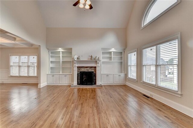 1054 Morgan Garner Dr SW, Lilburn, GA 30047 - unfurnished living room with high vaulted ceiling, a ceiling fan, a stone fireplace, and healthy amount of natural light