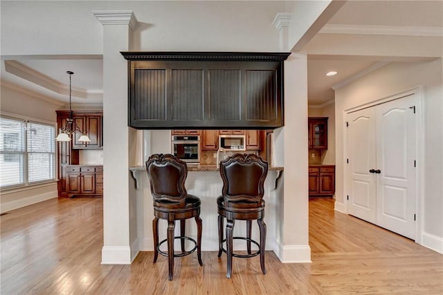 1054 Morgan Garner Dr SW, Lilburn, GA 30047 - kitchen with stainless steel appliances, crown molding, light wood finished floors, baseboards, and a kitchen breakfast bar