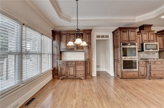 1054 Morgan Garner Dr SW, Lilburn, GA 30047 - kitchen with appliances with stainless steel finishes, a raised ceiling, light wood finished floors, baseboards, and crown molding