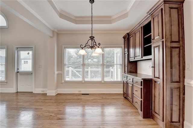 1054 Morgan Garner Dr SW, Lilburn, GA 30047 - unfurnished dining area with a chandelier, a raised ceiling, light wood-style flooring, crown molding, and baseboards
