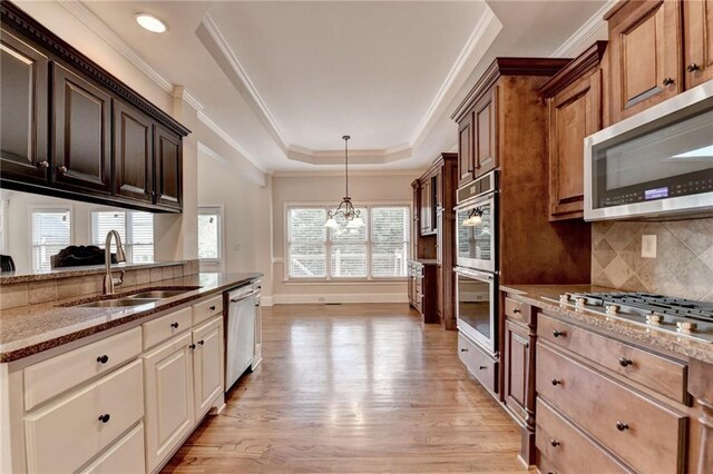 1054 Morgan Garner Dr SW, Lilburn, GA 30047 - kitchen featuring a sink, stainless steel appliances, a raised ceiling, light stone counters, and a chandelier