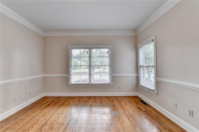 1054 Morgan Garner Dr SW, Lilburn, GA 30047 - empty room featuring healthy amount of natural light, wood finished floors, baseboards, and ornamental molding