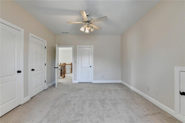 1054 Morgan Garner Dr SW, Lilburn, GA 30047 - unfurnished bedroom with carpet flooring, baseboards, two closets, and a ceiling fan
