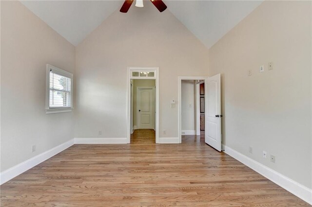 1054 Morgan Garner Dr SW, Lilburn, GA 30047 - unfurnished bedroom with high vaulted ceiling, light wood-style floors, baseboards, and ceiling fan