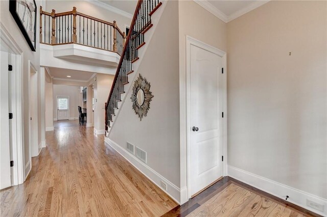 1054 Morgan Garner Dr SW, Lilburn, GA 30047 - corridor featuring light wood finished floors, stairway, crown molding, and baseboards