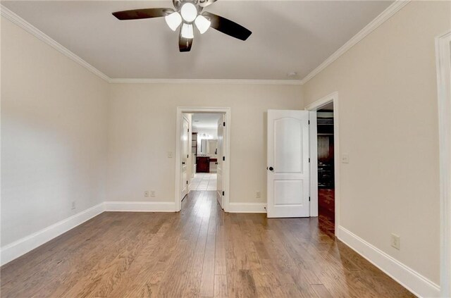 1054 Morgan Garner Dr SW, Lilburn, GA 30047 - spare room with ornamental molding, a ceiling fan, wood finished floors, and baseboards