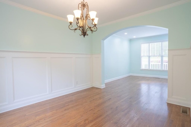 5746 Nix Bridge Rd, Gainesville, GA 30506 - unfurnished room with a decorative wall, arched walkways, a chandelier, wood finished floors, and wainscoting