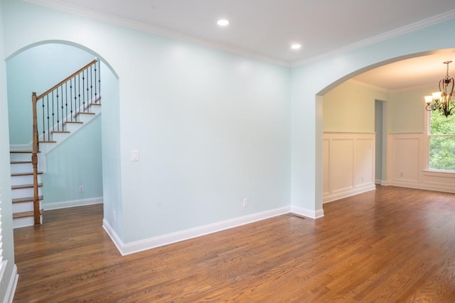 5746 Nix Bridge Rd, Gainesville, GA 30506 - empty room featuring wood finished floors, a chandelier, crown molding, arched walkways, and a wainscoted wall