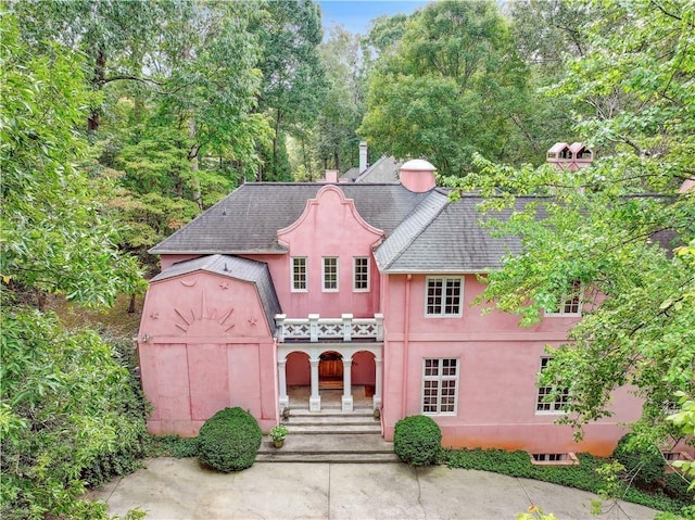 view of front of house featuring stucco siding and a shingled roof