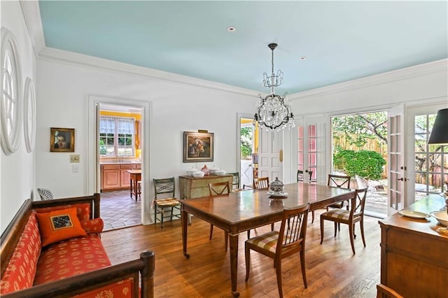 dining room featuring french doors, a notable chandelier, wood finished floors, and crown molding