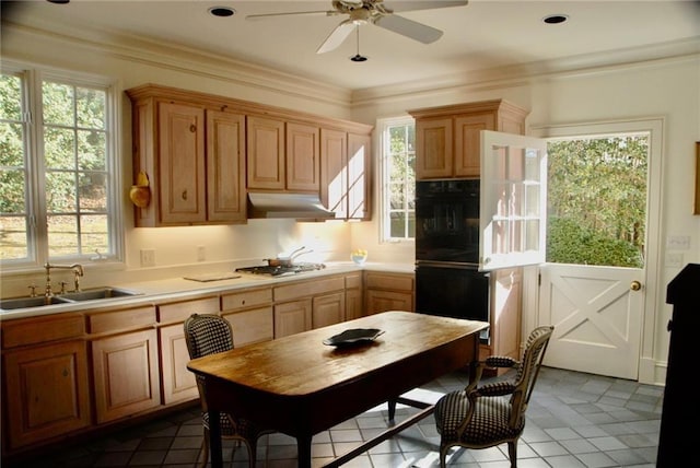 kitchen with under cabinet range hood, stainless steel gas cooktop, light countertops, dobule oven black, and a sink