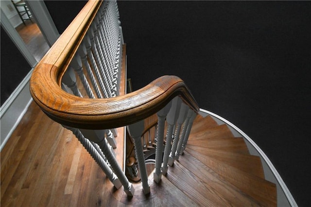 staircase featuring wood finished floors and baseboards