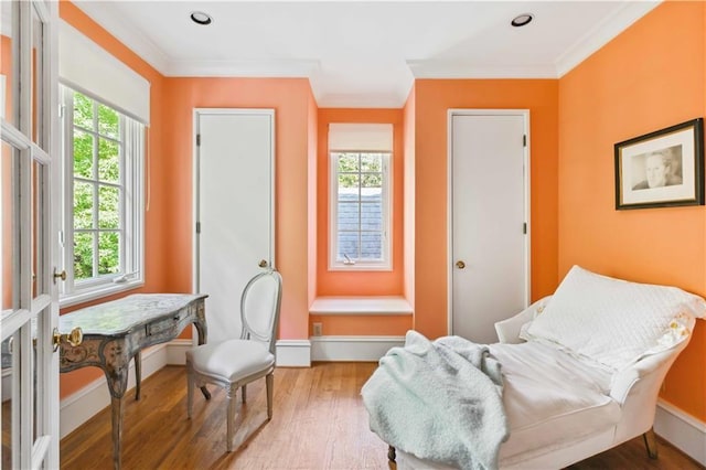 living area with crown molding, baseboards, and wood finished floors