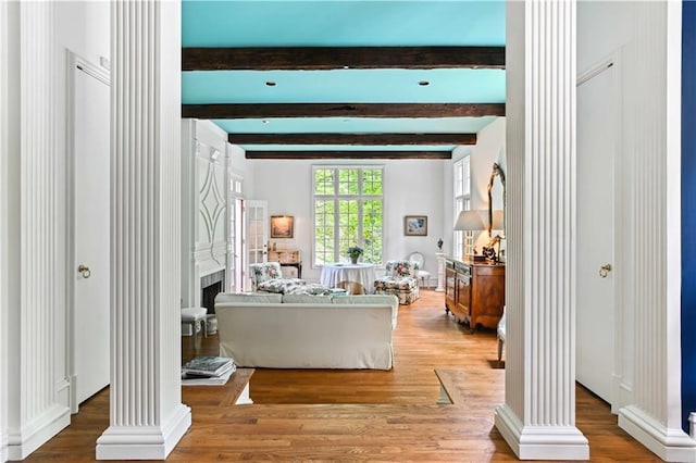 living room with beamed ceiling, ornate columns, and wood finished floors