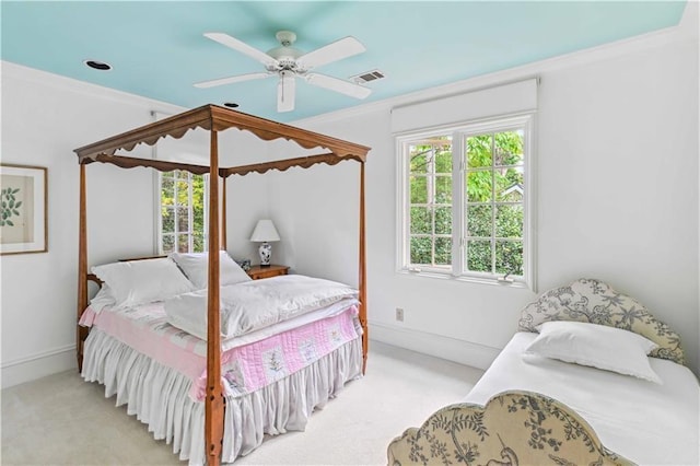 carpeted bedroom with a ceiling fan, crown molding, visible vents, and baseboards